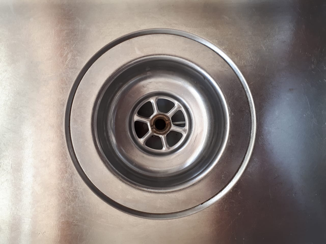 Kitchen sink drain cover and surrounding basin